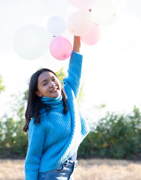 Foto garota feliz segura balão no maedow no inverno.