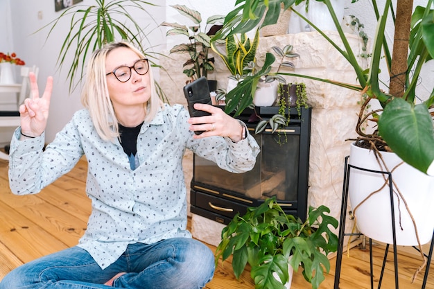 Garota feliz, sentado em casa cozinha e segurando videocall