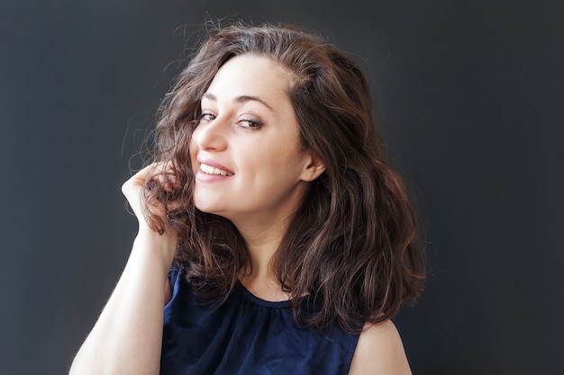 Garota feliz sorrindo. Positivo feliz novo do retrato da beleza mulher moreno de riso no preto isolado. Mulher européia. Emoção humana positiva expressão facial linguagem corporal