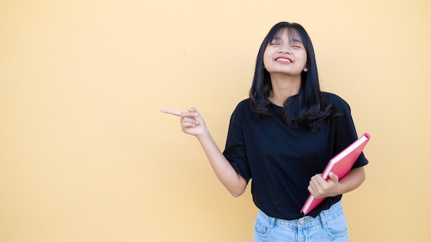 Garota feliz usa camisa preta em fundo laranja