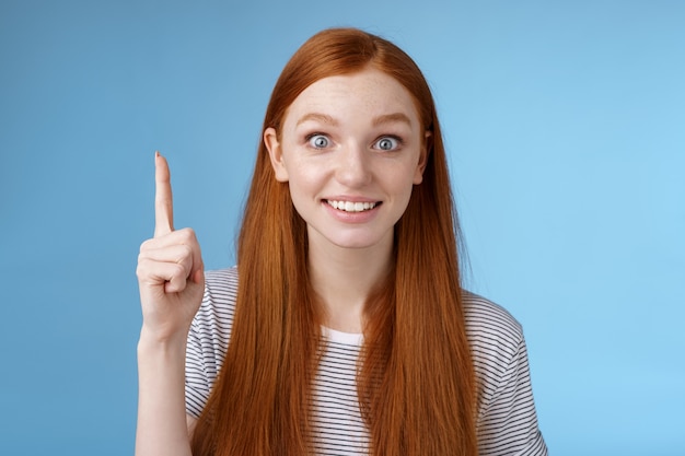 Garota fez uma excelente sugestão, pense em uma ótima ideia, levantando o dedo indicador eureka, fez um gesto sorrindo emocionada quero compartilhar o plano equipe falando olhar câmera emoção alegria, fundo azul permanente