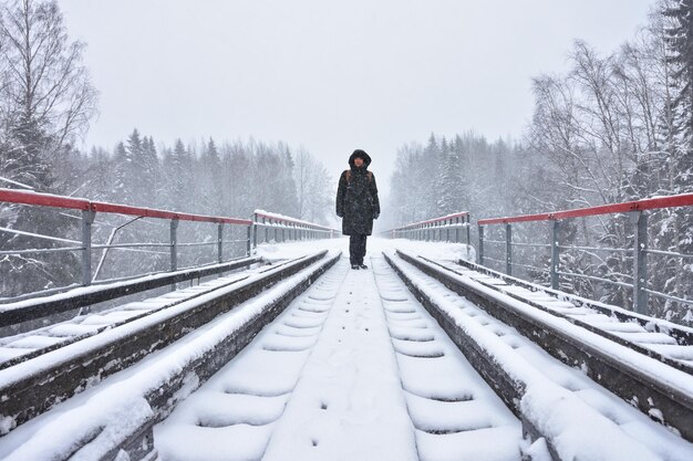 Garota fica na estrada de ferro na neve