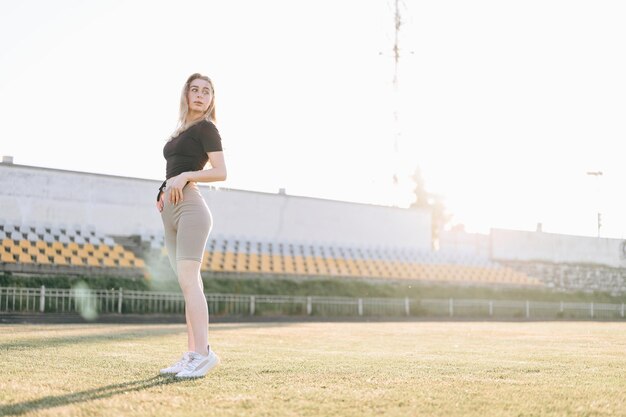 Garota fica no estádio ao pôr do sol