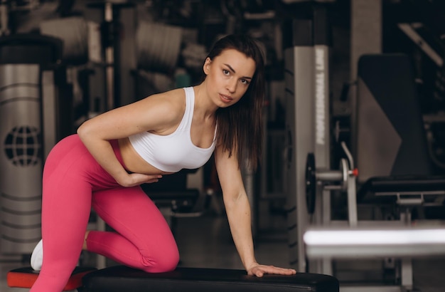 Garota fitness levantando halteres de manhã