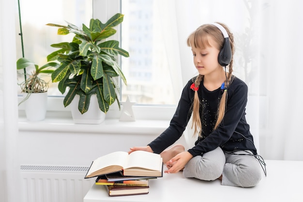 garota garoto com cabelo loiro em fones de ouvido ouve música. a distância social. quarentena e epidemia.