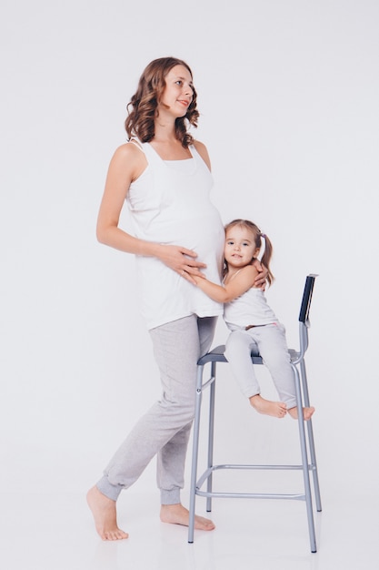 Garota garoto feliz abraçando a barriga da mãe grávida, gravidez e novo conceito de vida