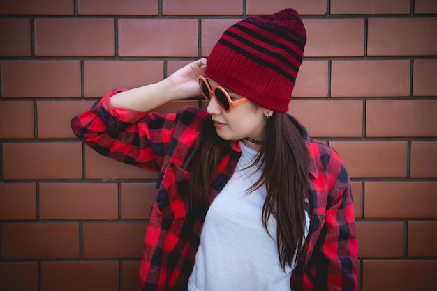 Garota hipster asiática de retrato no fundo da parede de tijolosEstilo de vida do povo da tailândia