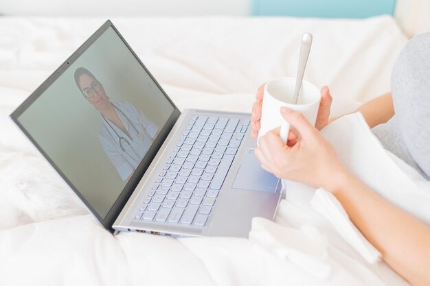 Garota irreconhecível assistindo a um vídeo com conselhos médicos em um laptop Uma mulher conversa online com um médico em uma webcam