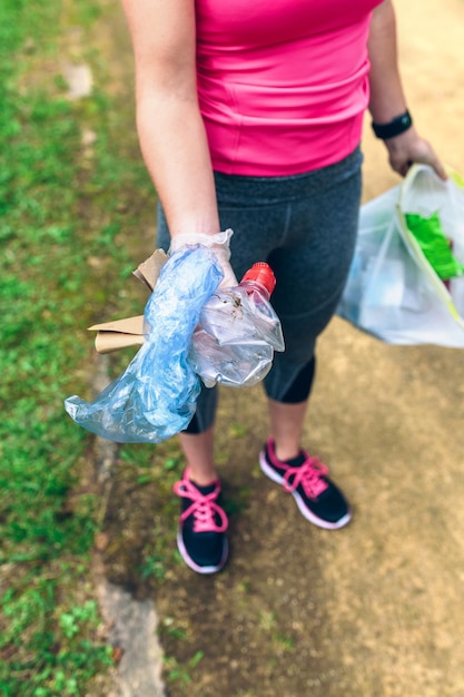 Foto garota irreconhecível mostrando o lixo que ela coletou