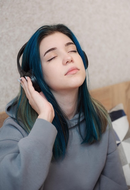 Garota jovem adolescente com cabelo azul e fones de ouvido