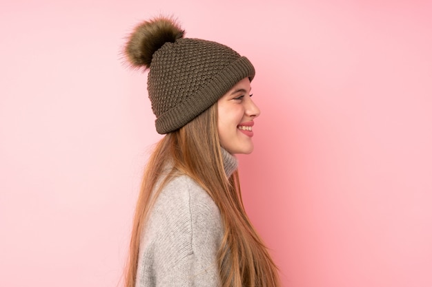 Foto garota jovem adolescente com fundo de chapéu de inverno, olhando para o lado