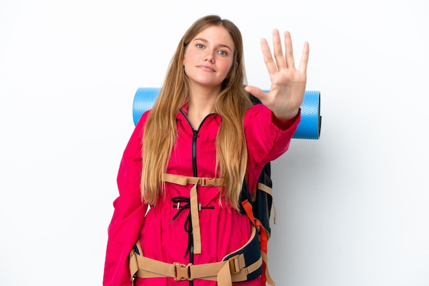 Garota jovem alpinista com uma mochila grande sobre fundo branco isolado contando cinco com os dedos