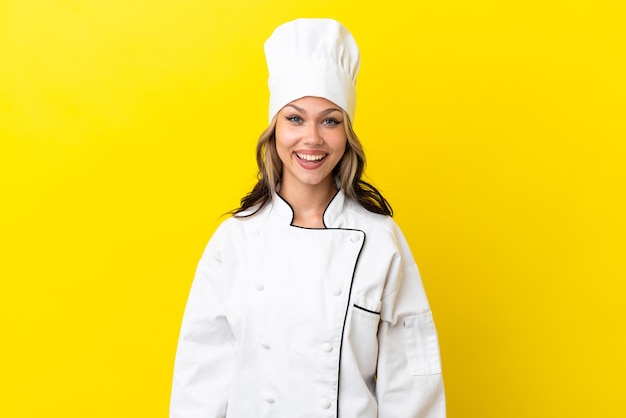 Garota jovem chef russo isolada em fundo amarelo com expressão facial de surpresa