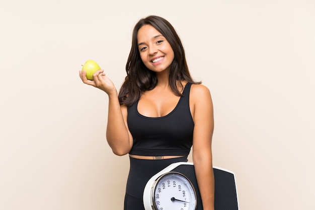 Foto garota jovem esporte com máquina de pesagem sobre fundo isolado