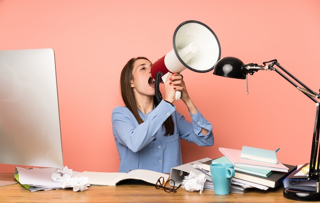 Garota jovem estudante gritando através de um megafone