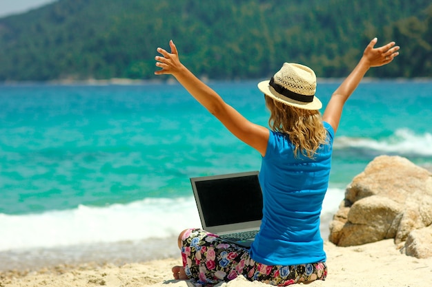 Garota legal com laptop à beira-mar trabalho de conceito