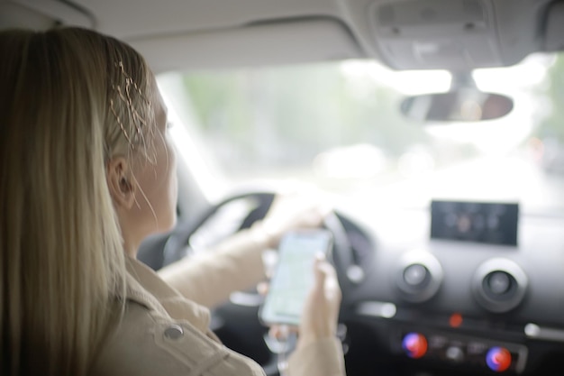 garota loira dirigindo / motorista loira bonita, conceito de viagem de verão. Jovem adulta dirigindo um carro