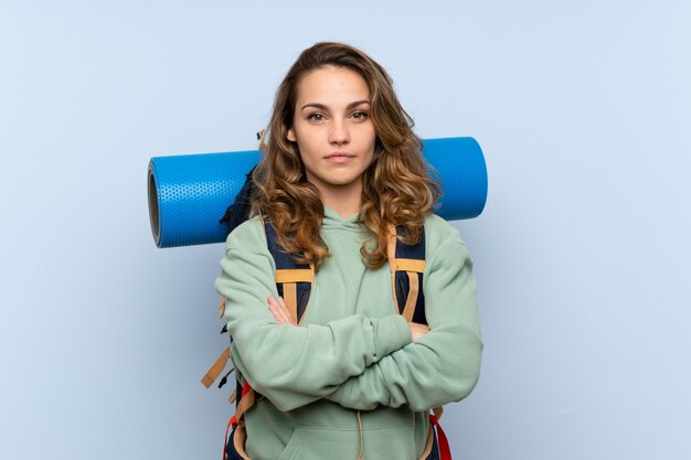 Garota loira jovem alpinista sobre fundo azul isolado