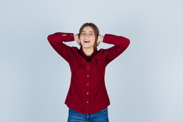 garota mantendo as mãos nas orelhas em uma camisa casual e parecendo feliz