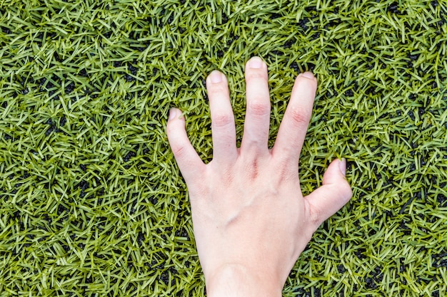 garota mão no fundo de grama de campo de futebol