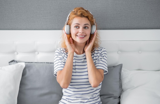 Garota melomaníaca feliz ouvindo música na cama Garota relaxante curtindo música
