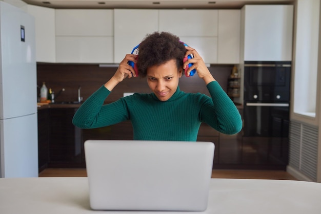 Foto garota milenar radiante usando fones de ouvido se diverte ouvindo música relaxando na sala de estar