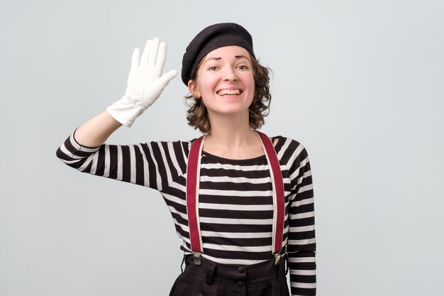 Garota mímica bonita caucasiana acenando com as mãos dizendo olá