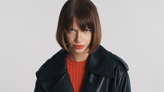 Foto garota morena séria com cabelo bob olhando debaixo da testa isolada em fundo branco garota irritada