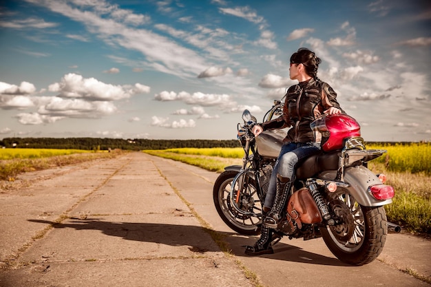 Garota motociclista em uma jaqueta de couro em uma motocicleta