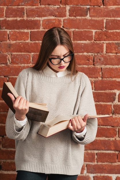 Garota muito esperta lendo dois livros ao mesmo tempo