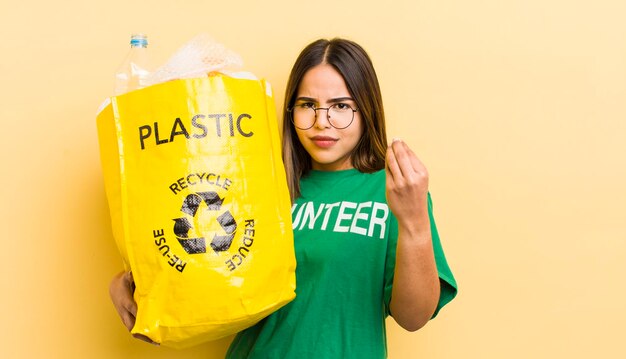 Garota muito hispânica fazendo gesto de capice ou dinheiro dizendo para você pagar o conceito de ecologia