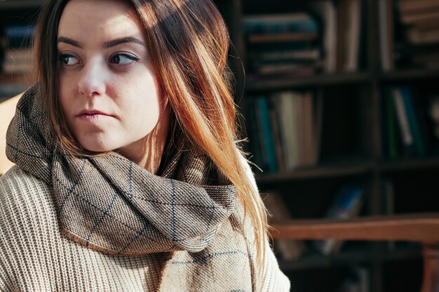 Garota muito jovem estudante na biblioteca