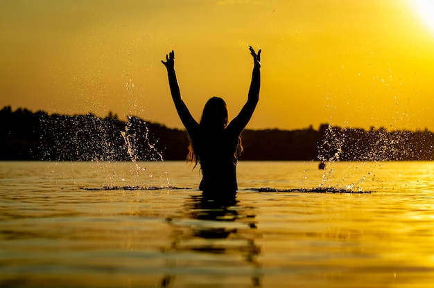 Foto garota na água ao pôr do sol
