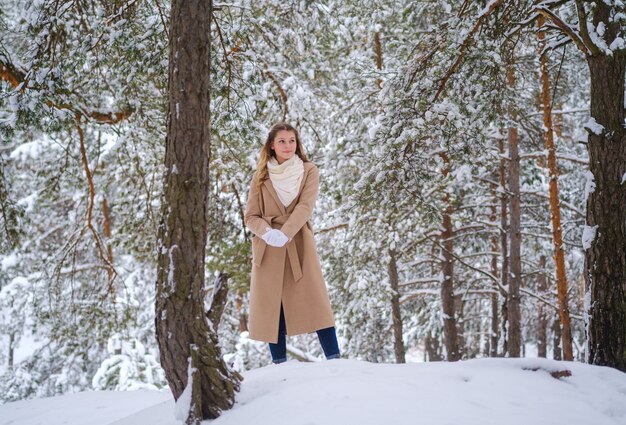 garota na floresta de inverno com árvores brancas e neve abundante