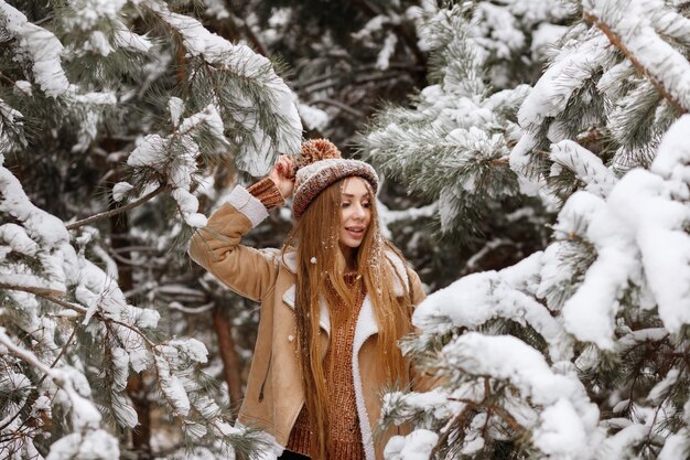 Garota na floresta de inverno feliz na neve