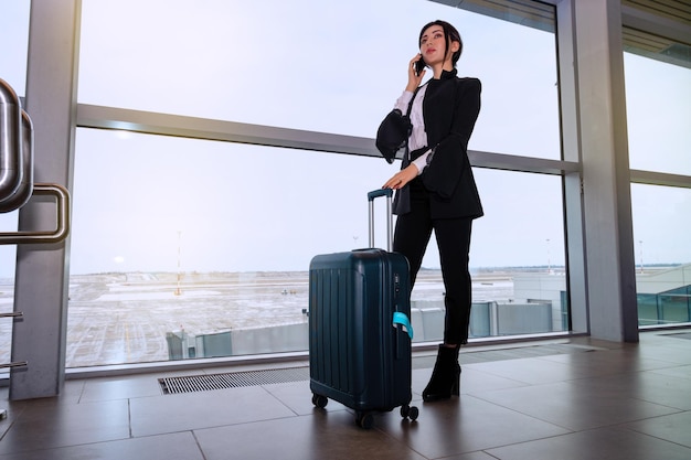 Garota na janela do aeroporto espera por um voo