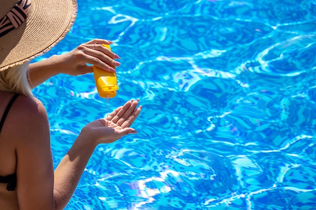 Garota na piscina mancha protetor solar Descanse foco seletivo