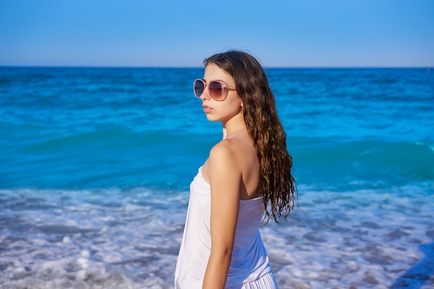 Garota na praia do mar com vestido de verão