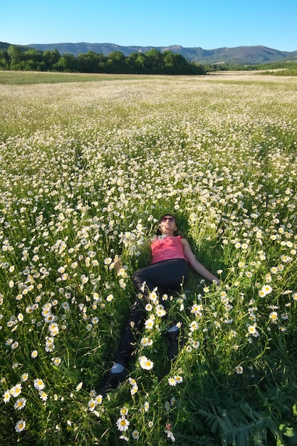 Garota no campo de flores da primavera da margarida