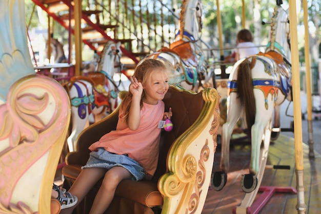 Garota no carrossel cavalos em um carnaval merry go round