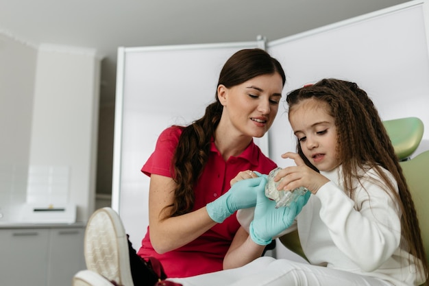 Foto garota no consultório do dentista mostra como escovar os dentes