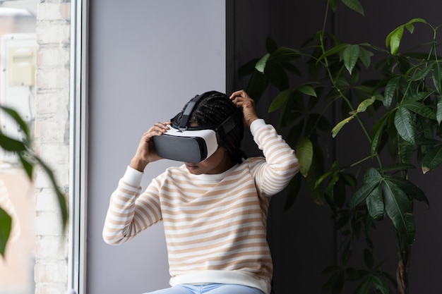 Garota no fone de ouvido vr assiste a vídeos ou joga jogos para entretenimento em casa, use óculos de realidade virtual