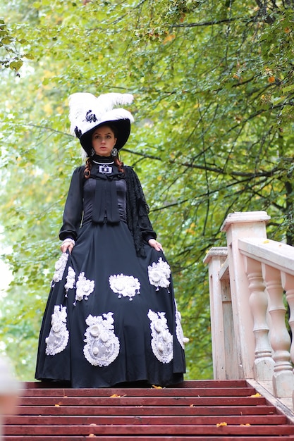 Garota no velho vestido retrô na escada ao ar livre