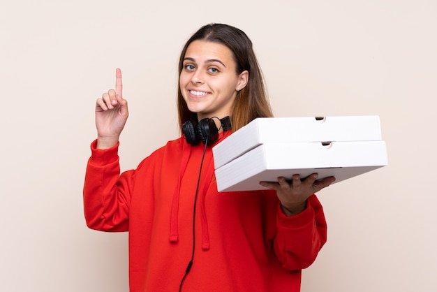 Garota pegando caixas de pizza sobre parede isolada