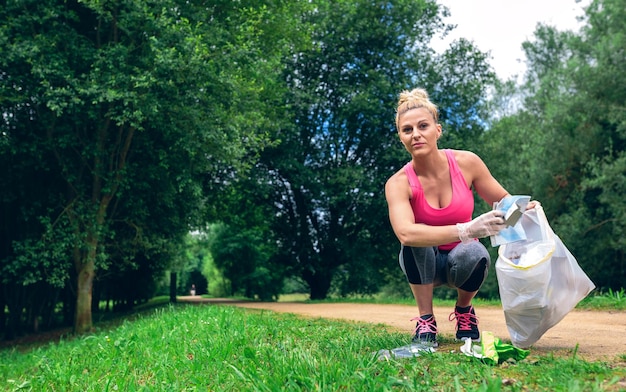 Garota pegando lixo fazendo plogging