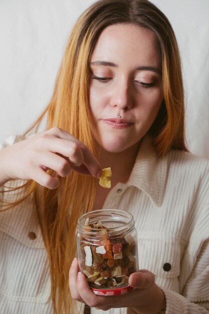 Garota pegando um pedaço de banana seca de uma jarra