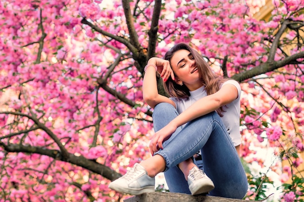 Foto garota posando com ramos de flores do lado de fora