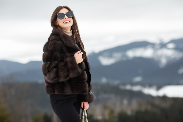 Garota posando nas montanhas de inverno