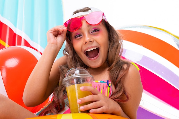 Foto garota positiva em um maiô com um sorriso largo no rosto, férias de verão, frutas frescas