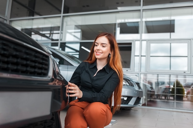 Garota positiva inspeciona um carro